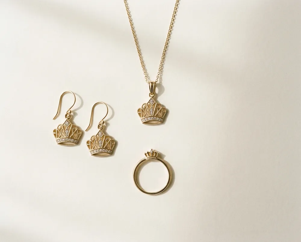 A pendant, drop earrings and a slim ring laid out on ivory